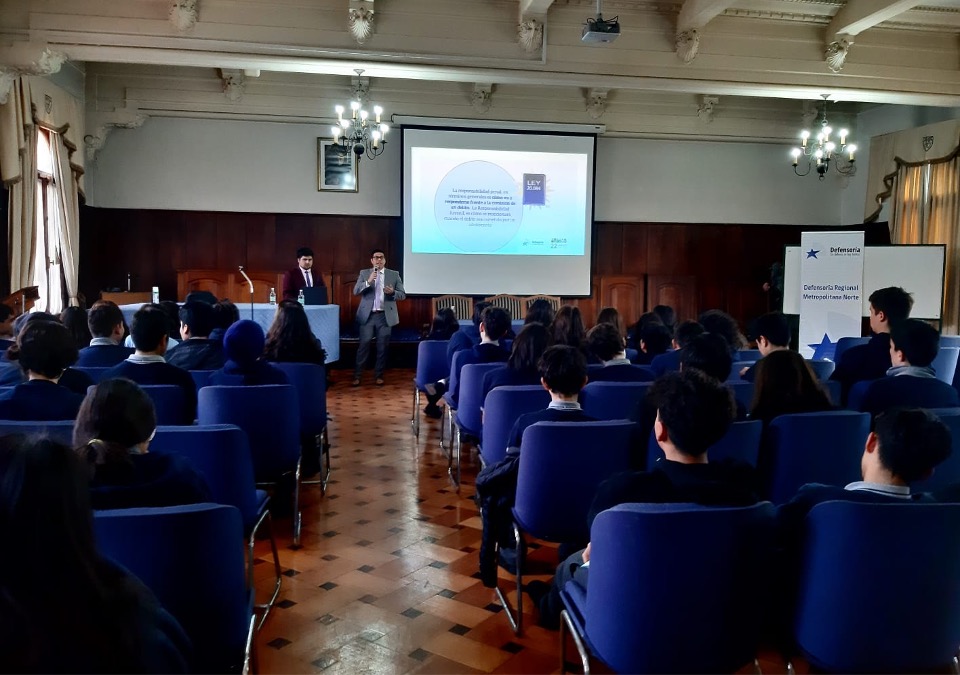 El defensor p&uacute;blico juvenil Cristi&aacute;n Esquivel en el auditorio del colegio, exponiendo ante 70 alumnos.