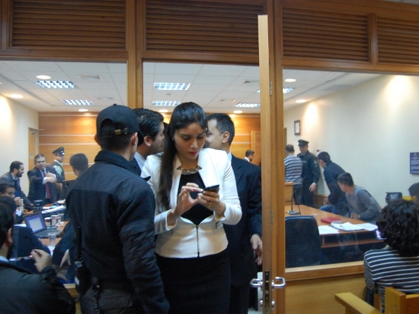 La defensora penal p&uacute;blica Carolina Arancibia aparece al salir en un receso de la audiencia, mientras que detr&aacute;s suyo se observa a otros interviniente