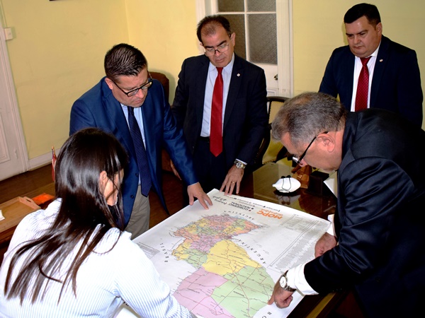 El c&oacute;nsul de Paraguay muestra las rutas comerciales a Chile en un mapa de su pa&iacute;s.
