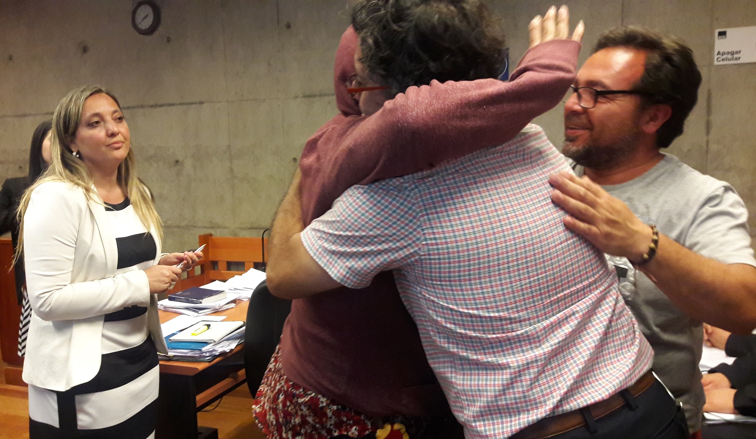 La defensora p&uacute;blica Alejandra Lobos observa el abrazo de dirigentes sindicales del Sename a una de las funcionarias acusadas. 