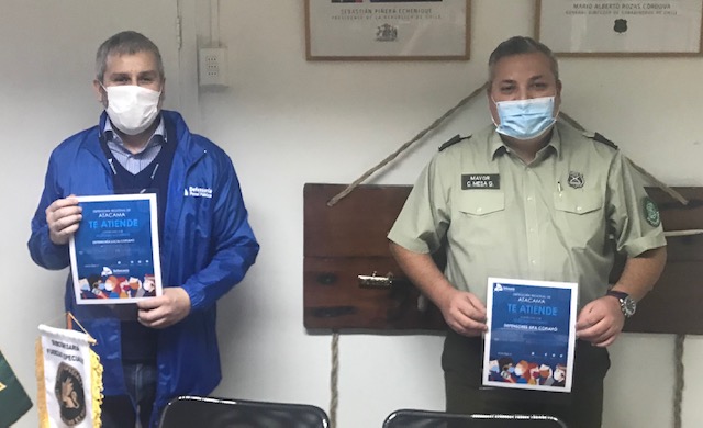 El Defensor Regional de Atacama, Ra&uacute;l Palma, y el mayor de Carabineros Carlos Mesa exhiben los afiches de difusi&oacute;n.