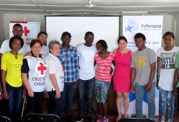 La defensora p&uacute;blica Pamela Urquhat junto a las voluntarias de la Cruz Roja y los migrantes haitianos que participaron en la charla.