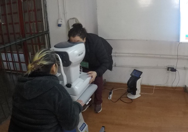 Un profesional del Cesfam realiza el examen oftalmol&oacute;gico a una mujer privada de libertad en el CPF de San Miguel.