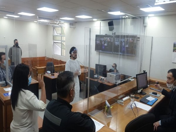 Al centro, entre los intervinientes en el primer juicio oral semipresencial realizado en Tarapac&aacute;, aparece el defensor p&uacute;blico Andr&eacute;s Hidalgo.