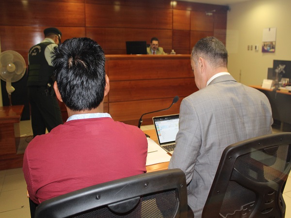 El defensor local jefe de Arica, Sergio Zenteno, junto a uno de los detenidos.