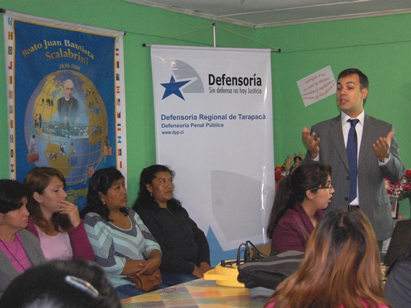 El jefe de Estudios de Tarapac&aacute;, Cristian Sleman, durante su charla ante inmigrantes en Iquique.
