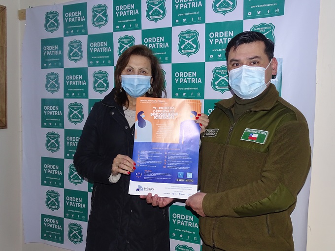 La Defensora Regional, Gustava Aguilar, entrega afiches y d&iacute;pticos al capit&aacute;n de Carabineros Fernando Qui&ntilde;i&ntilde;ir.