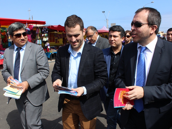 El subsecretario de Justicia, Ignacio Su&aacute;rez; el seremi de la cartera, Leonel Huerta, y el Defensor Regional, Claudio G&aacute;lvez, en feria libre en Arica.