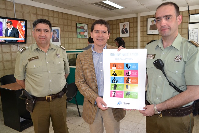 El defensor local jefe de Temuco, Patricio Salinas, entrega los afiches sobre derechos de los imputados.