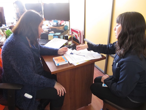 Marcia Pe&ntilde;a (a la derecha) entrega d&iacute;pticos de la Defensor&iacute;a en la Unidad de Extranjer&iacute;a de la Intendencia. 