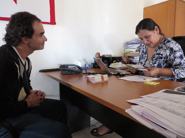 Elizabeth Vel&aacute;squez observa el d&iacute;ptico informativo que ser&aacute; entregado a los usuarios de su oficina.