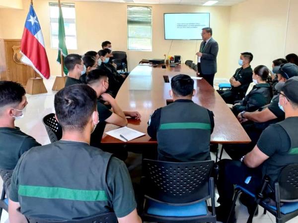 El grupo de gendarmes atendiendo la exposici&oacute;n del Defensor Regional de Tarapac&aacute;.