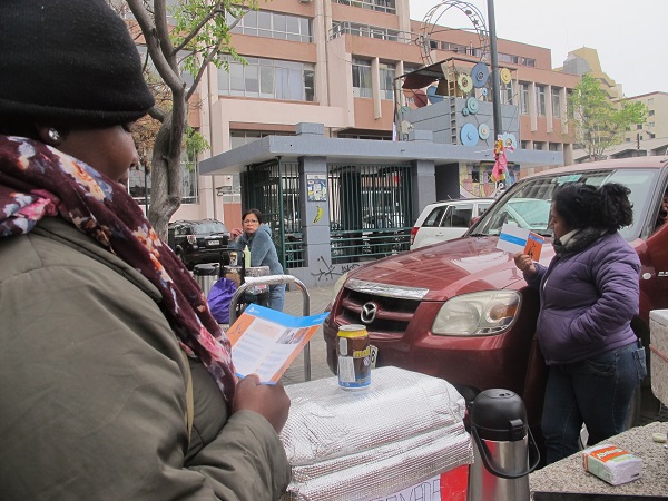 En la plaza c&iacute;vica, los ciudadanos haitianos leen el d&iacute;ptico sobre defensa de extranjeros.