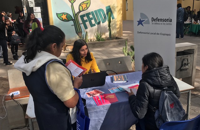 La asistente social Yesenia Cort&eacute;s explica a una alumna de la Universidad de Atacama cu&aacute;l es su rol en la Defensor&iacute;a.