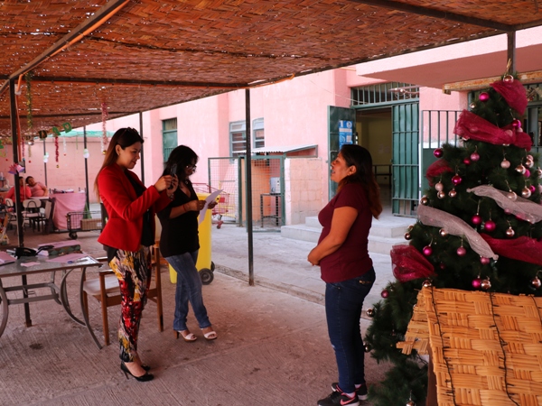 La encargada de comunicaciones junto a  la facilitadora intercultural grabando el saludo de una imputada para sus familiares.