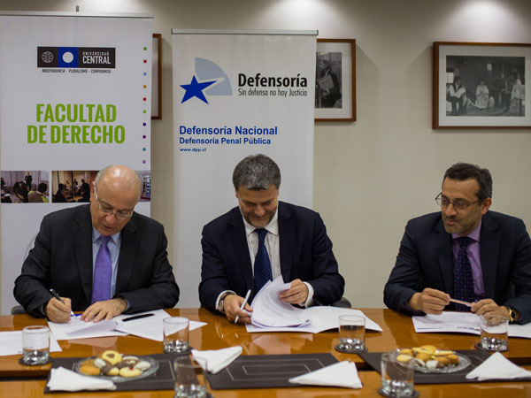 Andr&eacute;s Mahnke y Santiago Gonz&aacute;lez al suscribir el convenio. Los observa el Defensor Regional Metropolitano Norte, Carlos Mora.