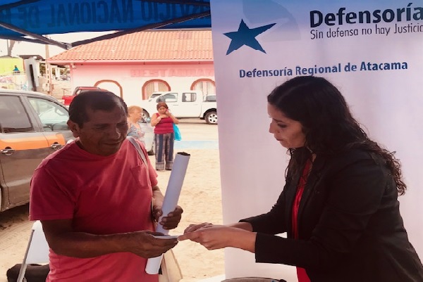 La asistente social Yesenia Cort&eacute;sFlores explica el quehacer institucional a un vecino del puerto de Caldera. 
