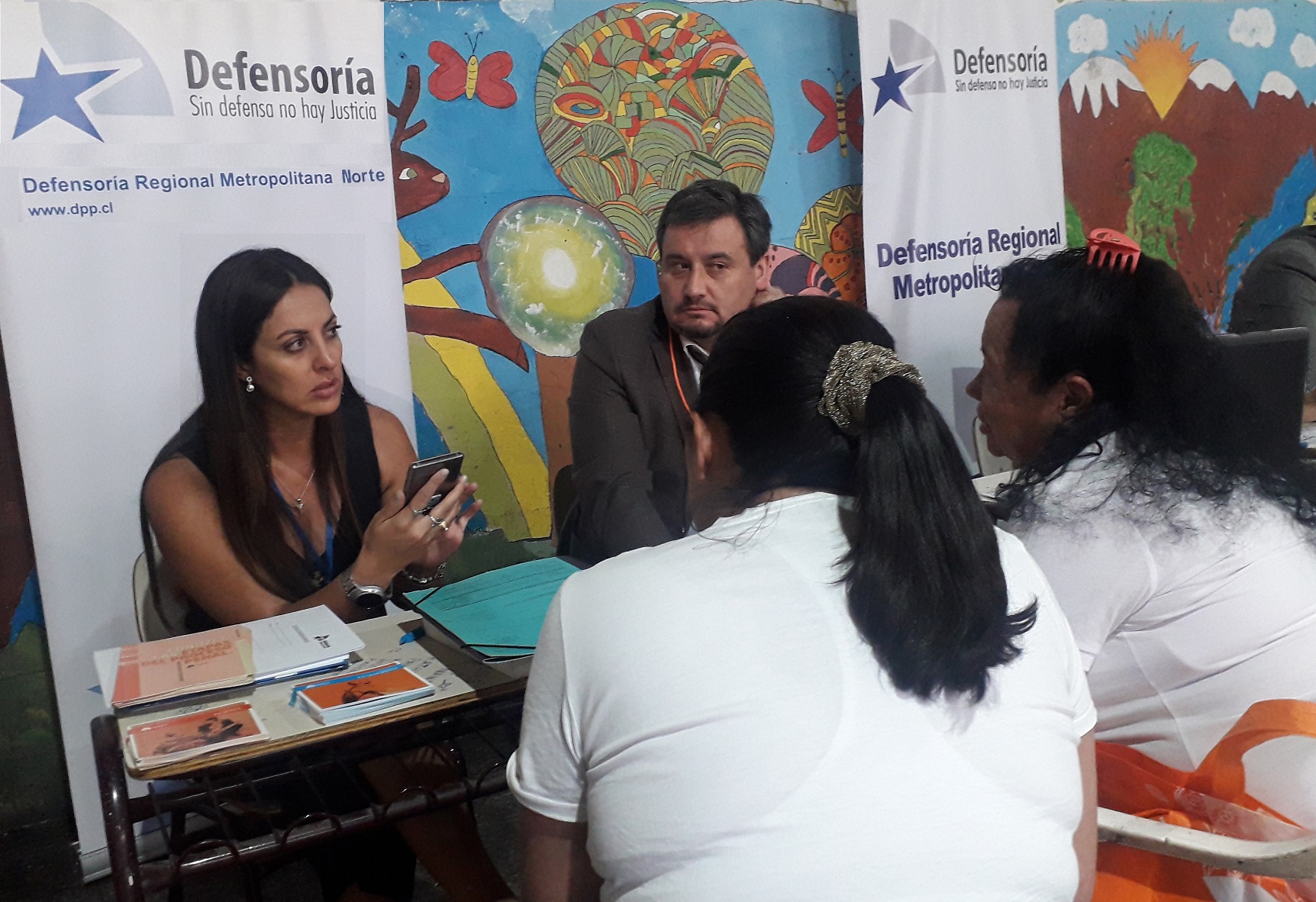 Los defensores p&uacute;blicos Patricia Alvarado y Mauricio Jara explican sus derechos a las imputadas migrantes en prisi&oacute;n preventiva.