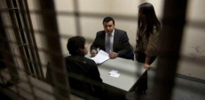 Defensor juvenil y asistente social atendiendo a un joven imputado