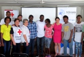 La defensora Pamela Urquhat juntoa alas voluntarias de la Cruz Roja y los haitianos que participaron de la actividad