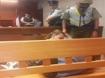 La defensora penal juvenil Carla Saavedra despierta con ternura a su joven defendido que dorm&iacute;a en un banca del tribunal