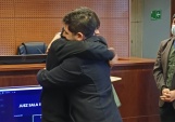 El defensor penal juvenil Joaqu&iacute;n M&uuml;ller junto a Isaac en ceremonia de egreso de TTD en el Centro de Justicia de Santiago.