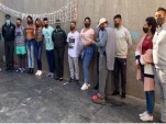 Gendarme e internos del penal de Alto Hospicio muestras las nuevas mascarillas confeccionadas all&iacute; mismo. 