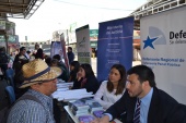 El defensor penal juvenil Luis Acu&ntilde;a, junto a la alumna en pr&aacute;ctica Camila Williams atendiendo en Feria Pinto de Temuco
