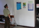 Carabinero de turno en la Cuarta Comisar&iacute;a de Santiago observa los afiches instalados por la DRMN sobre los Derechos del Detenido